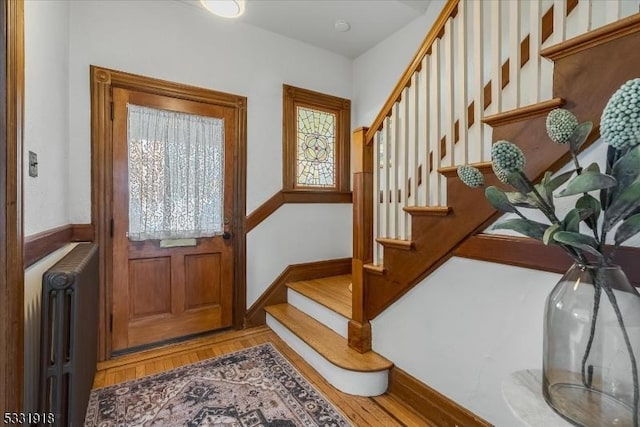 entryway with hardwood / wood-style floors and radiator heating unit