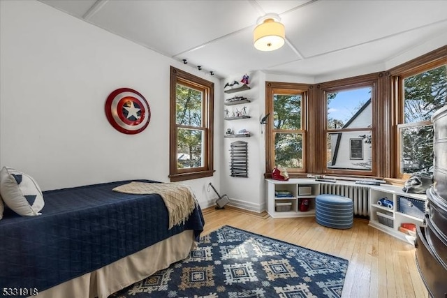 bedroom with wood-type flooring and radiator