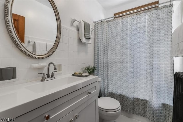 bathroom featuring backsplash, toilet, vanity, and tile walls