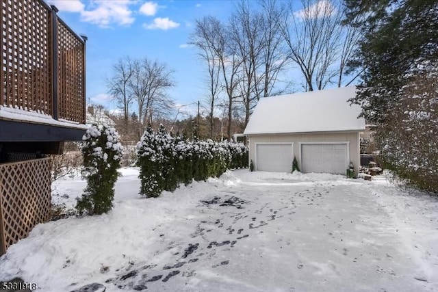 yard covered in snow with a garage and an outbuilding