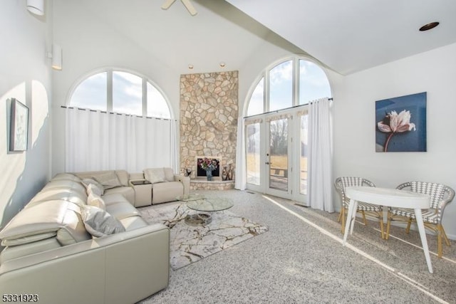 living room featuring plenty of natural light, a fireplace, and high vaulted ceiling