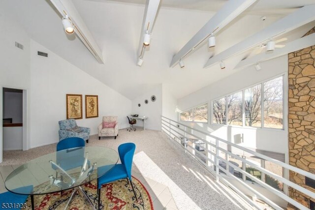 interior space with carpet flooring, ceiling fan, beam ceiling, and high vaulted ceiling