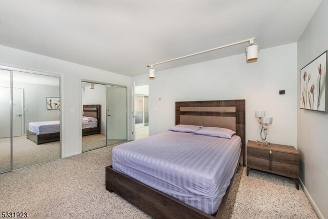 bedroom featuring multiple closets and carpet