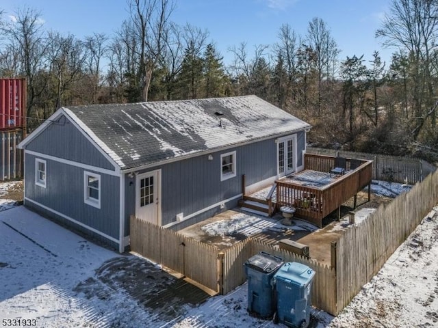 snow covered rear of property featuring french doors