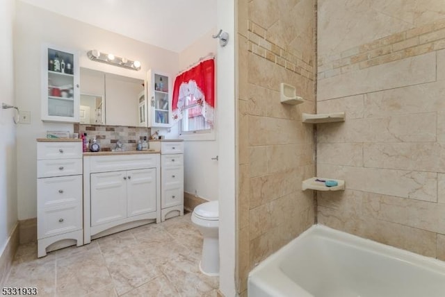 bathroom featuring tasteful backsplash, vanity, and toilet