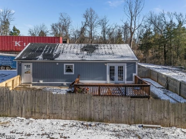 snow covered property featuring french doors and a wooden deck