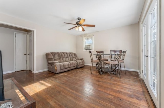 living room featuring ceiling fan and dark wood-type flooring