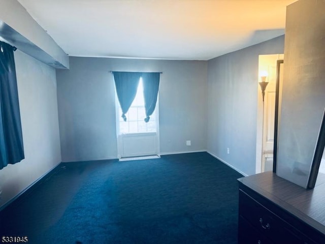 empty room with dark colored carpet