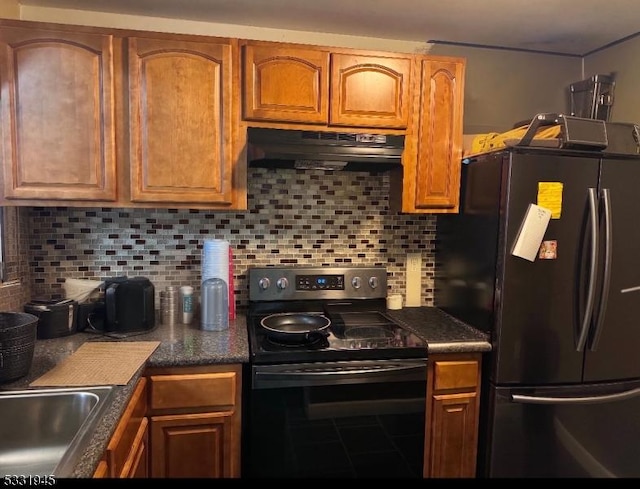 kitchen featuring backsplash, refrigerator, stainless steel range with electric cooktop, and sink