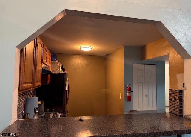 kitchen with decorative backsplash and black fridge