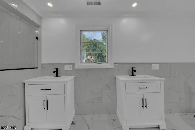 bathroom with vanity, ornamental molding, and tile walls