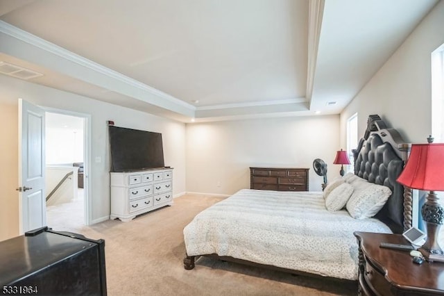 carpeted bedroom with a raised ceiling and crown molding