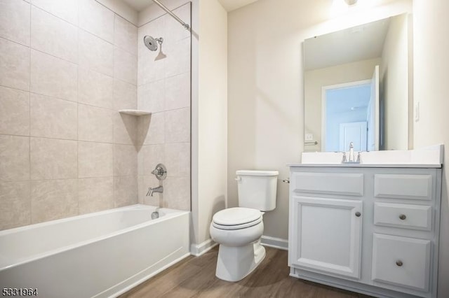 full bathroom featuring toilet, tiled shower / bath combo, vanity, and hardwood / wood-style floors