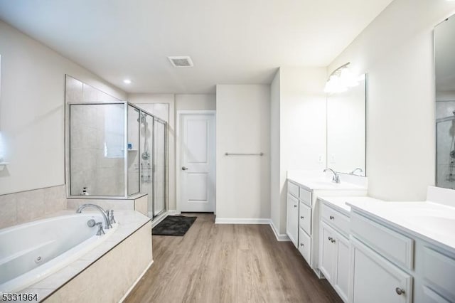 bathroom with shower with separate bathtub, vanity, and hardwood / wood-style flooring