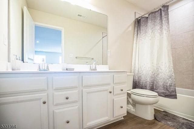 full bathroom with toilet, shower / tub combo with curtain, vanity, and hardwood / wood-style flooring