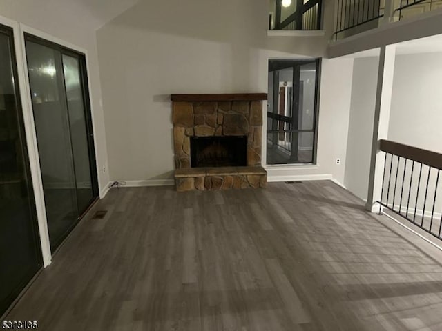 unfurnished living room with a fireplace and dark wood-type flooring