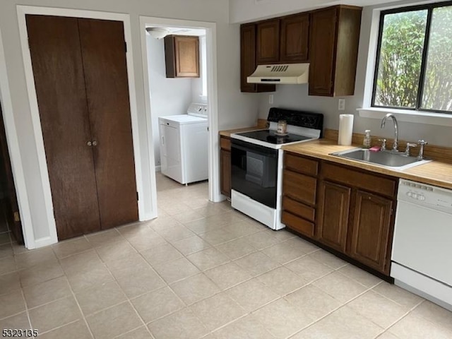 kitchen featuring dark brown cabinets, sink, light tile patterned flooring, and white appliances