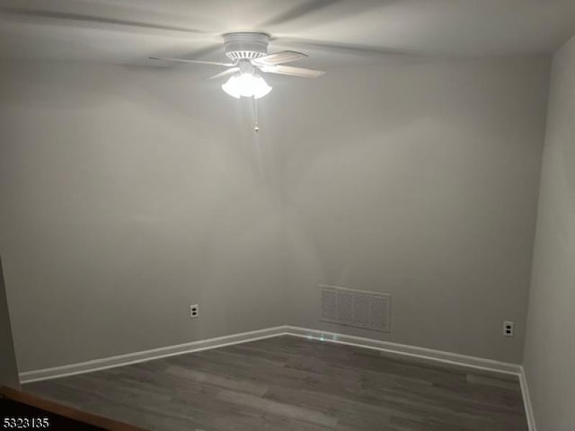 empty room with ceiling fan and dark hardwood / wood-style floors