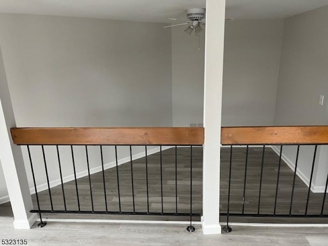 stairs featuring ceiling fan and hardwood / wood-style flooring