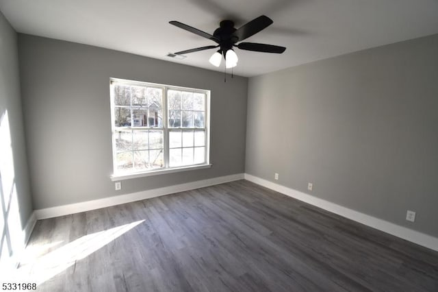 empty room featuring dark hardwood / wood-style flooring and ceiling fan