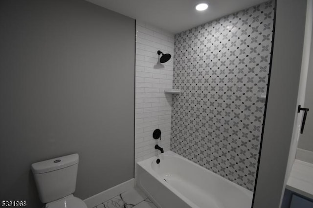 bathroom featuring tiled shower / bath combo and toilet