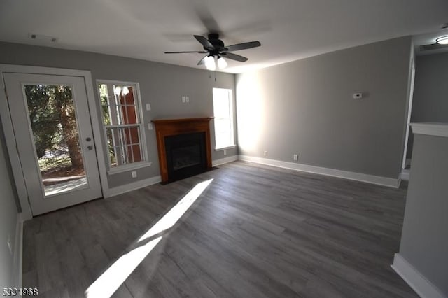 unfurnished living room with ceiling fan, plenty of natural light, and dark hardwood / wood-style floors