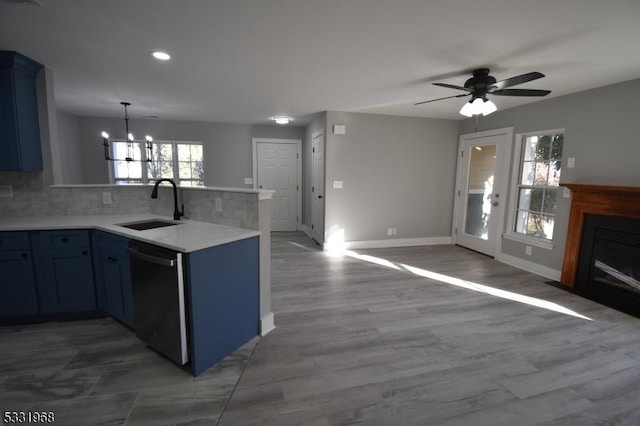 kitchen with ceiling fan with notable chandelier, sink, black dishwasher, tasteful backsplash, and kitchen peninsula