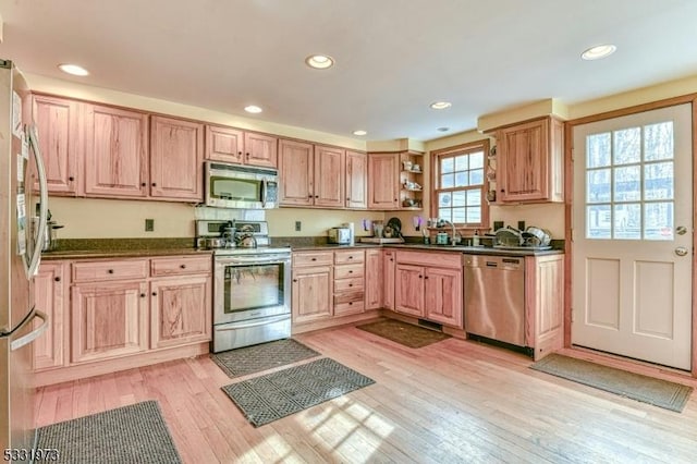 kitchen featuring light wood-type flooring, appliances with stainless steel finishes, and sink