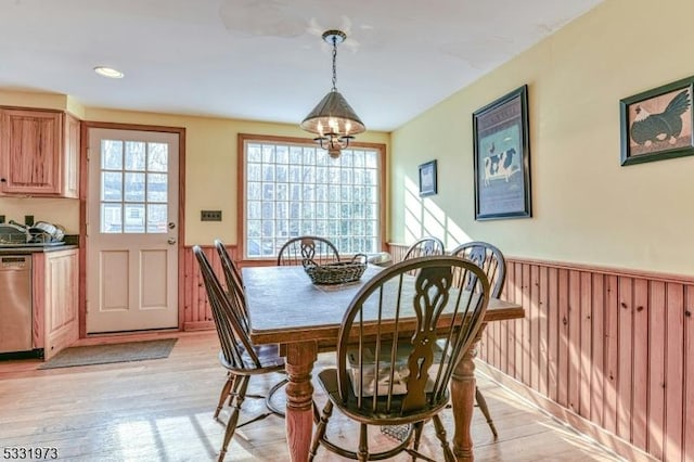 dining space featuring light wood-type flooring and a notable chandelier