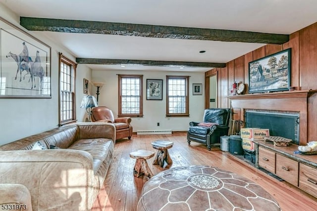 living room with light hardwood / wood-style floors, baseboard heating, beam ceiling, and a fireplace