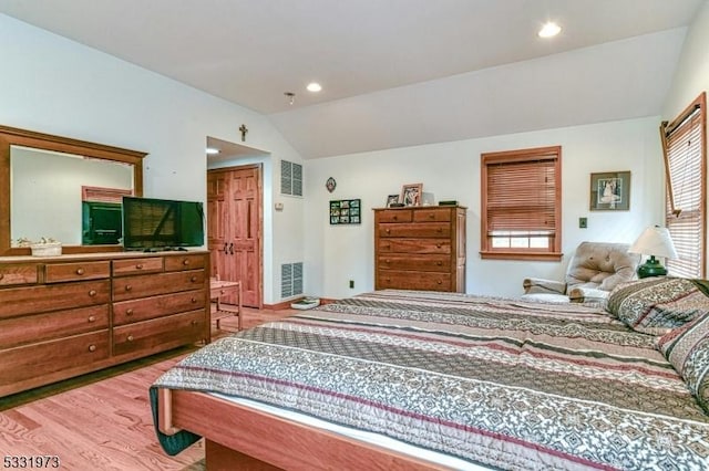 bedroom featuring lofted ceiling and light hardwood / wood-style floors