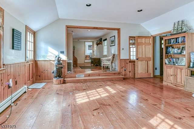 interior space featuring vaulted ceiling, hardwood / wood-style floors, a baseboard heating unit, and wooden walls