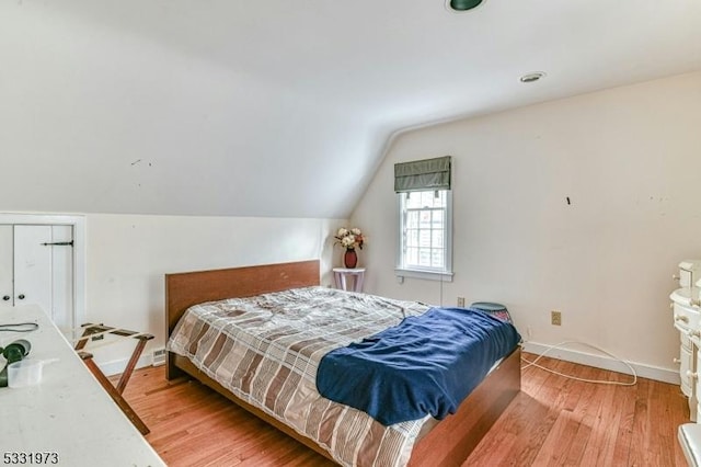 bedroom featuring wood-type flooring and vaulted ceiling