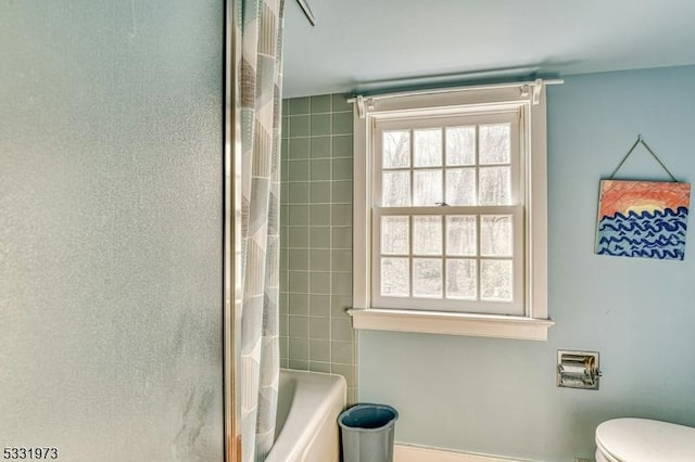 bathroom featuring toilet and shower / tub combo with curtain