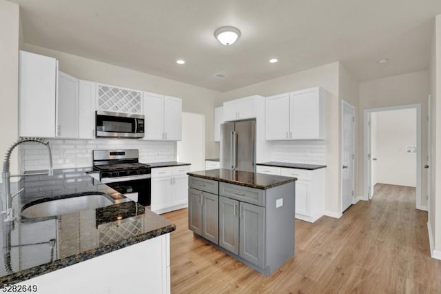 kitchen featuring gray cabinetry, a center island, sink, white cabinetry, and stainless steel appliances