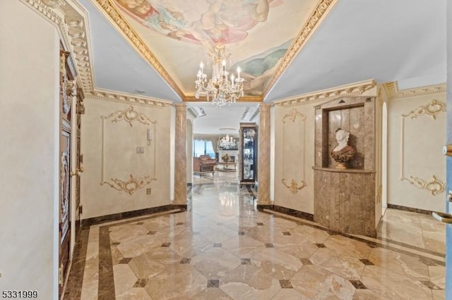 foyer entrance with a raised ceiling, an inviting chandelier, and ornamental molding