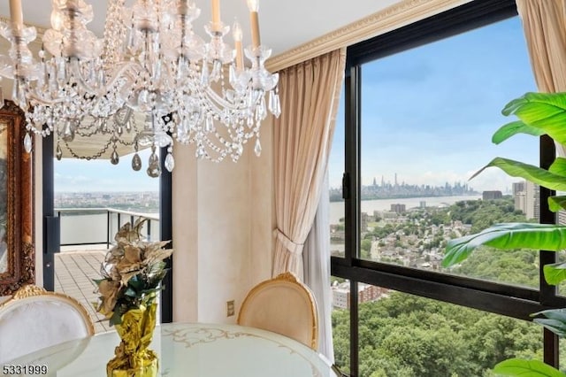 sunroom / solarium featuring a water view and a notable chandelier