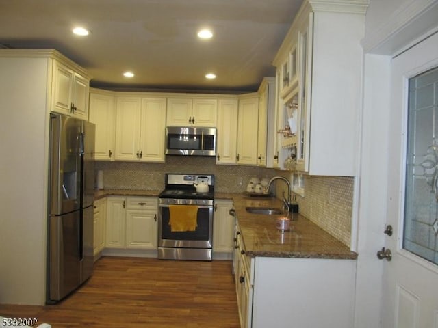 kitchen featuring decorative backsplash, dark stone countertops, sink, and appliances with stainless steel finishes