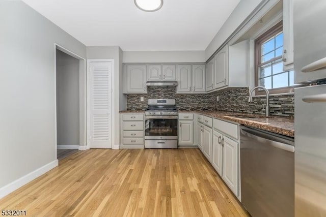 kitchen with sink, gray cabinets, stainless steel appliances, and light hardwood / wood-style flooring