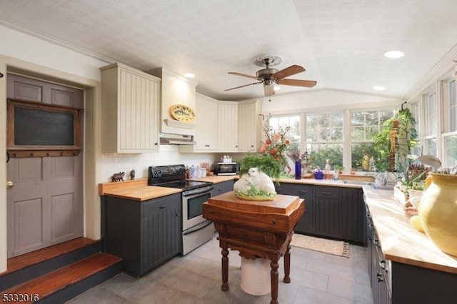 kitchen with wood counters, backsplash, ceiling fan, lofted ceiling, and stainless steel electric range