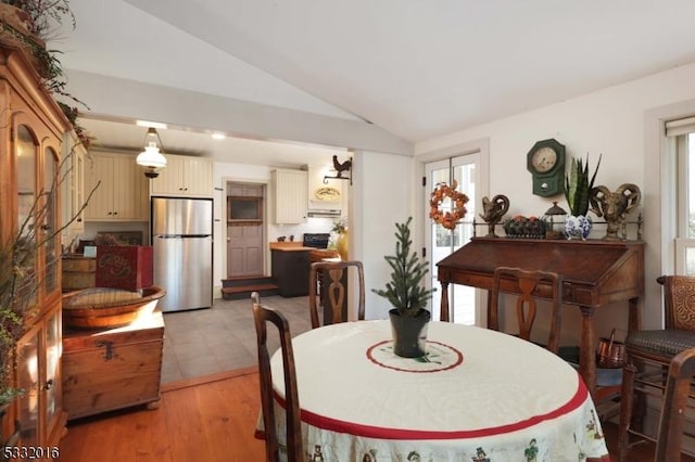 dining area with light hardwood / wood-style floors and lofted ceiling