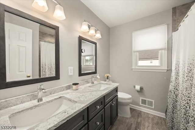 bathroom with hardwood / wood-style floors, vanity, and toilet