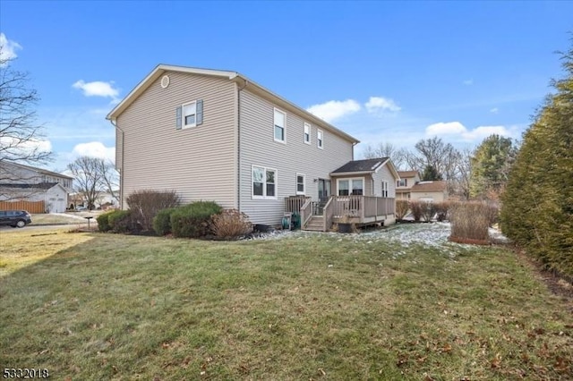 back of property featuring a deck and a lawn