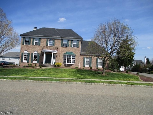 colonial home featuring a front yard