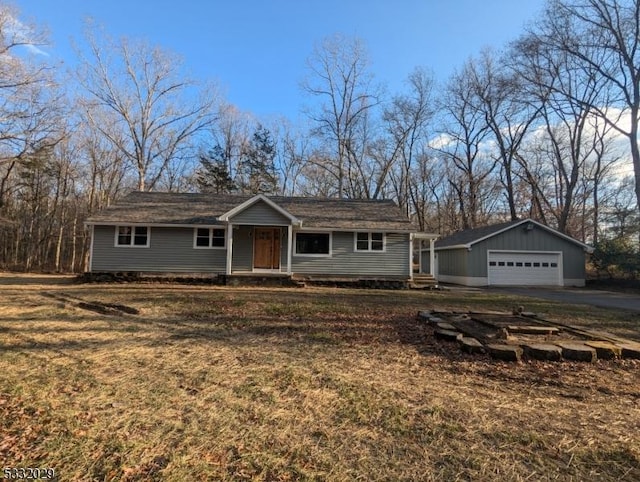 view of front of home featuring a garage, an outbuilding, and a front yard