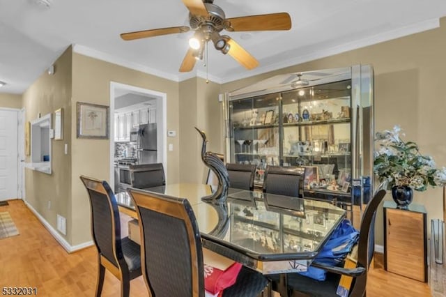 dining space featuring ceiling fan, light wood-type flooring, and ornamental molding