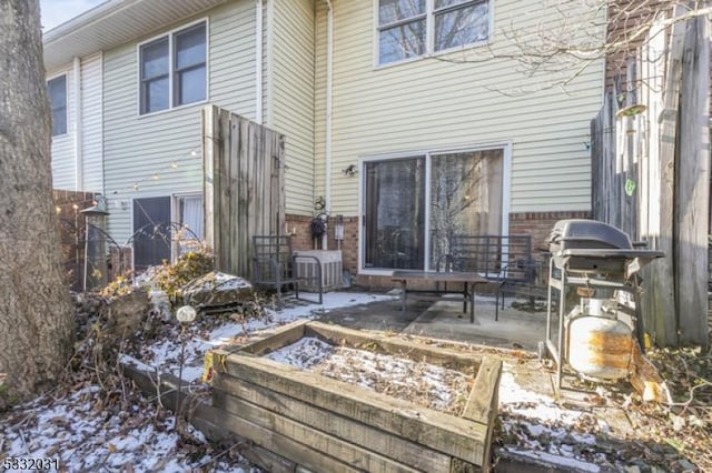 snow covered property featuring a patio