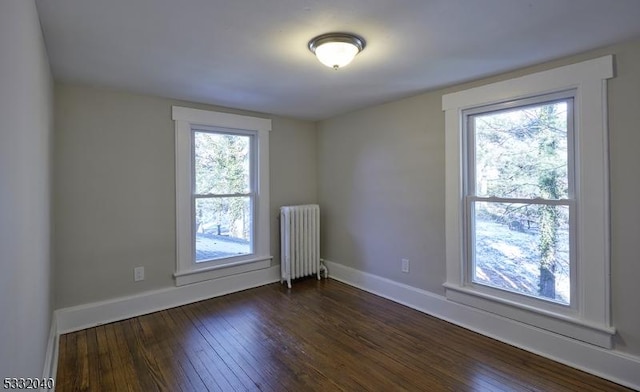 empty room with radiator and dark wood-type flooring