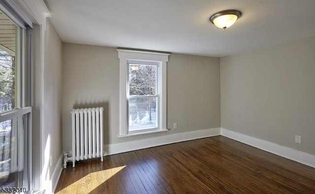 spare room with radiator and dark wood-type flooring