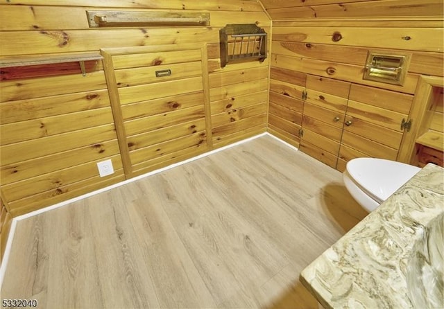 living area featuring light hardwood / wood-style flooring and wood walls